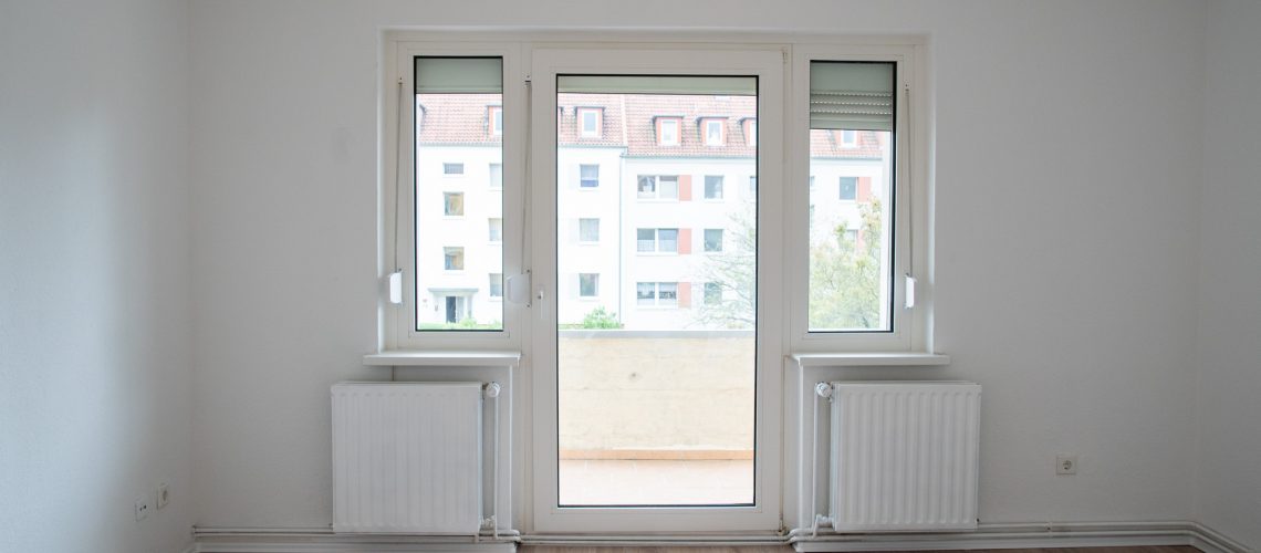Das Wohnzimmer mit Zugang zum Balkon lädt mit dem hellen Laminat, frisch gestrichenen Heizkörpern und Wänden zum Wohlfühlen ein.
