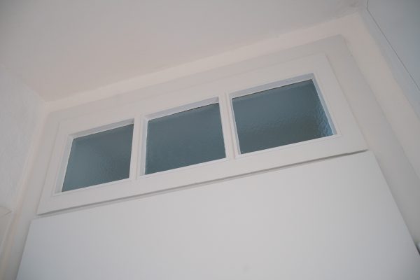 Die Wohnungstür haben wir komplett neu aufgearbeitet und die dicke Farbschicht in den Fenstern entfernt.